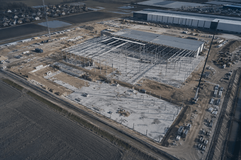 Aerial shot of a logistics centre under construction - steel structure and foundations, drone view