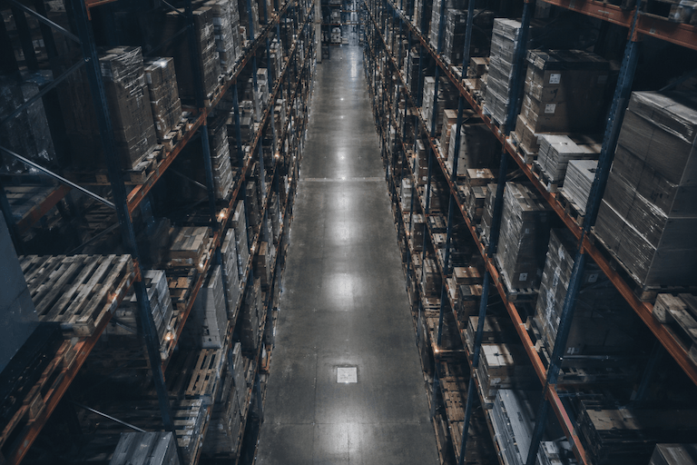 Interior of a high-bay warehouse - drone view between racking with pallets